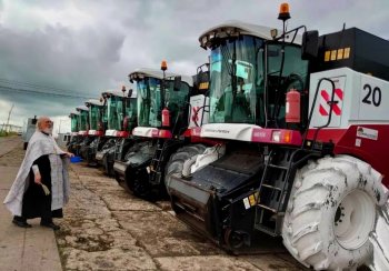 Na některých farmách nechybí u zemědělských stroj ani tradiční modlitební služba za přítomnosti faráře. Zdroj foto - Jurij Leontjev  