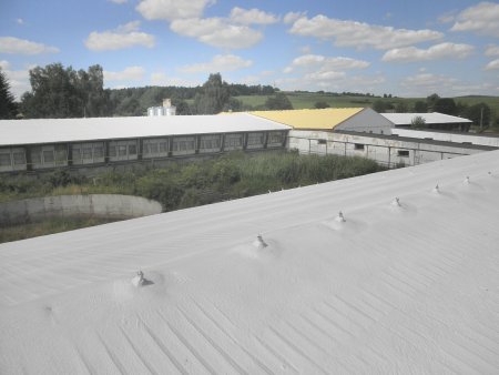 Izolace střech farmy chovu králíků. Bílé střechy jsou dokončené, žlutá střecha je před aplikací bílého nátěru.