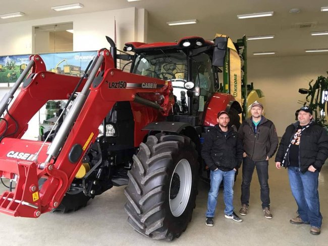 Milan Šelmeci (uprostřed) si přebírá nový traktor.
