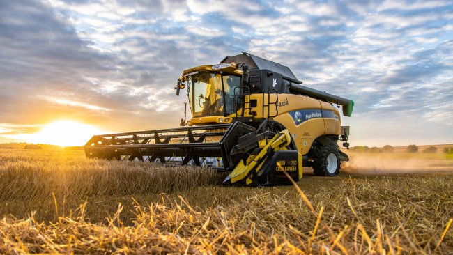 Sklízecí mlátička „JARÍK“ New Holland CX 8080 s žací lištou BISO VX 750 Crop Ranger při západu slunce.