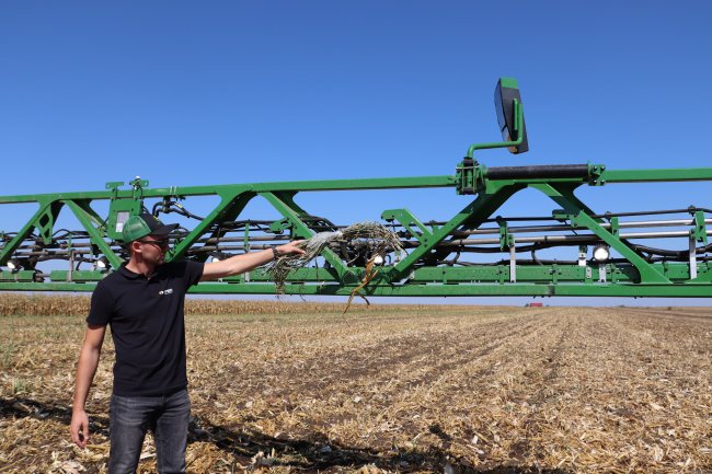 Kamery a další hardwarové komponenty jsou integrované přímo do ramen. Zástupce firmy John Deere na fotografii zkouší reakci kamery na zelenou barvu.