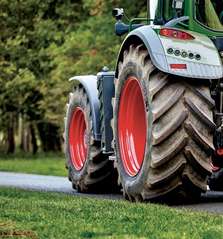 Traktor zezadu, detail zadních kol na silnici.
