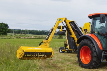 Traktor Kubota vybavený ramenovým mulčovačem ORSI pro údržbu krajiny a příkopů.