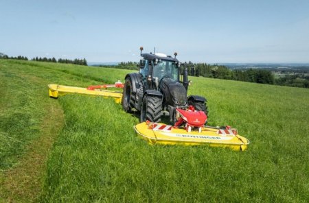 Traktor s čelní a zadní sekačkou Pöttinger NOVACAT F 3100 OPTICURVE při práci na louce.