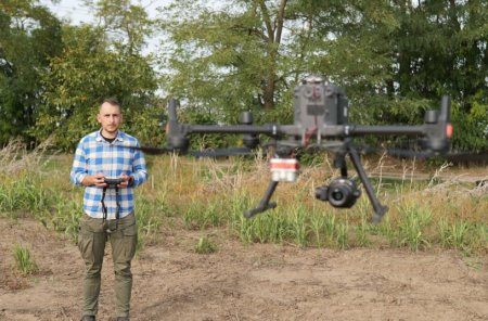 Farmář ovládá dron pro mapování a sběr dat z pole.