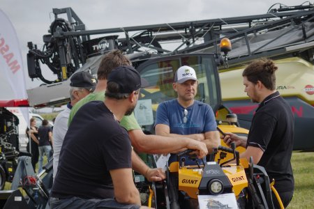 Návštěvníci Dne zemědělce diskutují s odborníkem o technice GIANT přímo u vystaveného stroje.