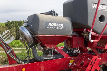 Dodatečný zásobník MiniDrill o objemu 400 l slouží pro drobná semena či mikrogranuláty. Všimněte si též přehledně uspořádaných přívodů u hydraulického dmychadla.