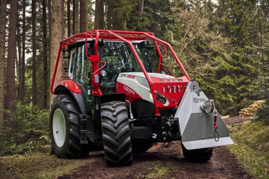 Lesní speciál Steyr 4120 Expert v úpravě pro práci v náročném terénu. Ochranný rám chrání traktor při pohybu mezi stromy, vpředu nechybí ani lesnický naviják.