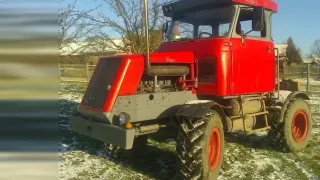 Doma postavený červený traktor z dílů nákladních vozidel
