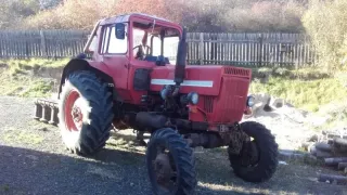 Červený traktor Belarus MTZ-82 v zemědělském areálu