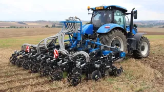 Traktor s technikou pro pásové zpracování půdy na poli