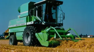 Zelený lis Deutz-Fahr při práci na poli.