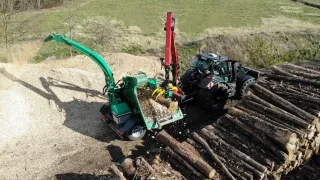 Traktor s mobilním štěpkovačem při zpracování dřeva