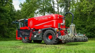 Červený čtyřkolový aplikátor Vervaet Quad na louce