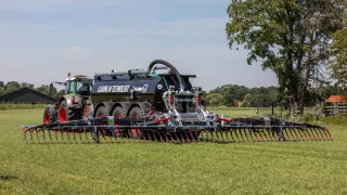 Traktor s cisternou a širokým aplikátorem hnojiv Vogelsang BlackBird na louce