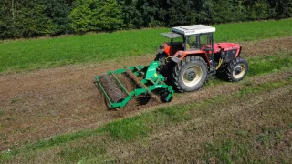 Červený traktor s diskovým podmítačem SUKOV na poli