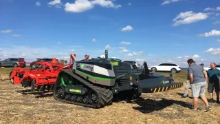 Pásový autonomní polní robot AgXeed AgBot vystavený na poli