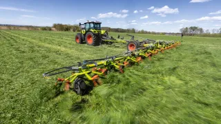 Traktor Claas s širokým obracečem Volto na louce.