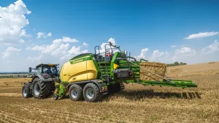Traktor s velkoformátovým lisem Krone BiG Pack na poli.