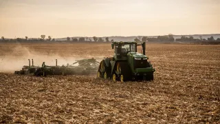 Autonomní traktor John Deere 9RX při práci na poli.