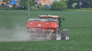 Traktor s rozmetadlem hnojiv RAUCH AXIS na poli