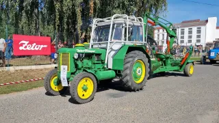 Historický zelený traktor Zetor před transparentem značky