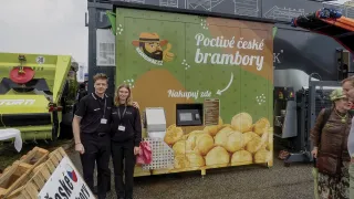 Dva lidé u zeleného automatu na brambory