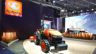 Oranžový traktor Kubota na výstavním stánku