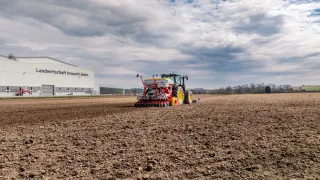 Traktor se secím strojem PÖTTINGER AEROSEM M na poli