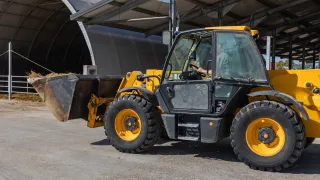 Kolový nakladač s lopatou slámy na farmě