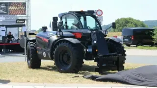 Černý teleskopický manipulátor Manitou na výstavě