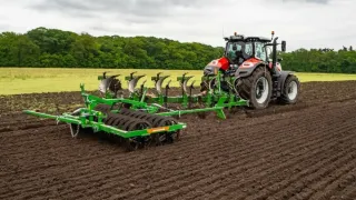 Traktor s pluhem AMAZONE při orbě pole