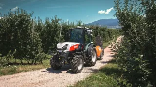 Traktor Steyr mezi řadami ovocných stromů