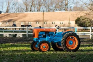 Historický modrooranžový traktor Lamborghini na trávníku