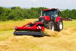 Červený traktor Case IH s čelním sběračem píce SIP.