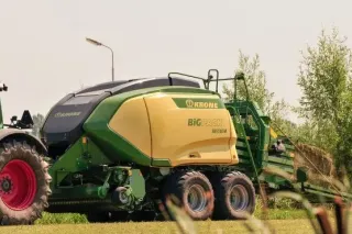 Lis Krone BiG Pack připojený k traktoru při práci na poli