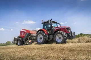 Traktor Massey Ferguson s lisem při práci na louce