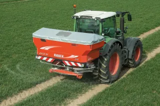 Traktor s rozmetadlem hnojiva Rauch na poli