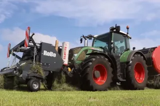 Traktor s přídavným řezáním a lisem na louce