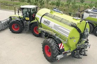 Traktor Claas se zelenou cisternou Kaweco ve dvoře