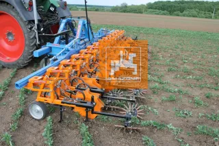 Oranžový meziřádkový kultivátor Schmotzer na poli