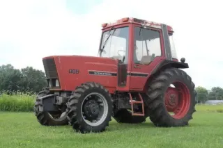 Starší červený traktor International na louce