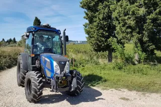 Modrý sadový traktor Landini Rex mezi stromy