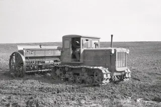 Archivní černobílý snímek pásového traktoru DT-54 se secím strojem