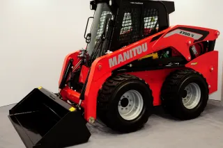Červený smykem řízený nakladač Manitou na bílém pozadí