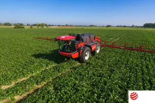 Červený samojízdný postřikovač Agrifac na zeleném poli