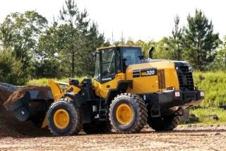 Žlutý kolový nakladač Komatsu u hromady štěrku