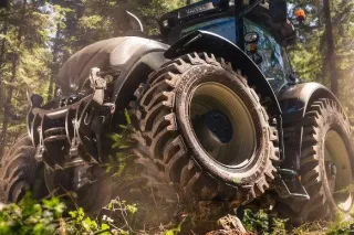 Detail velkých lesních pneumatik na traktoru mezi stromy