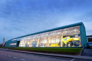 Prosklená budova výrobního závodu New Holland za soumraku