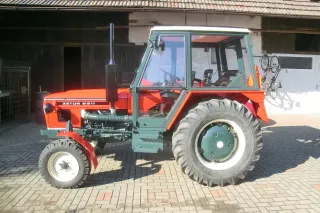 Zrenovovaný červený traktor Zetor 6911 na dvoře